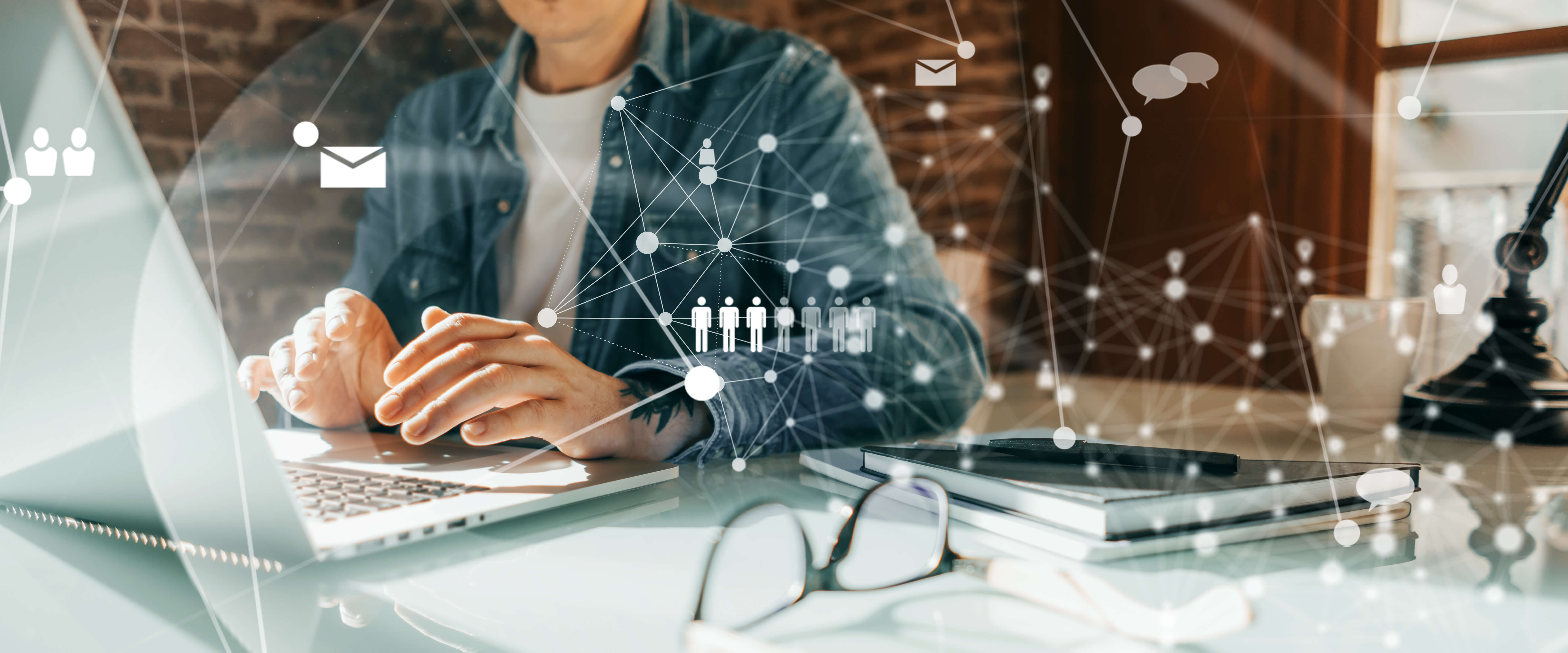 Mitarbeiter am Laptop, umgeben von vernetzten Cloud- und Kommunikations-Symbolen